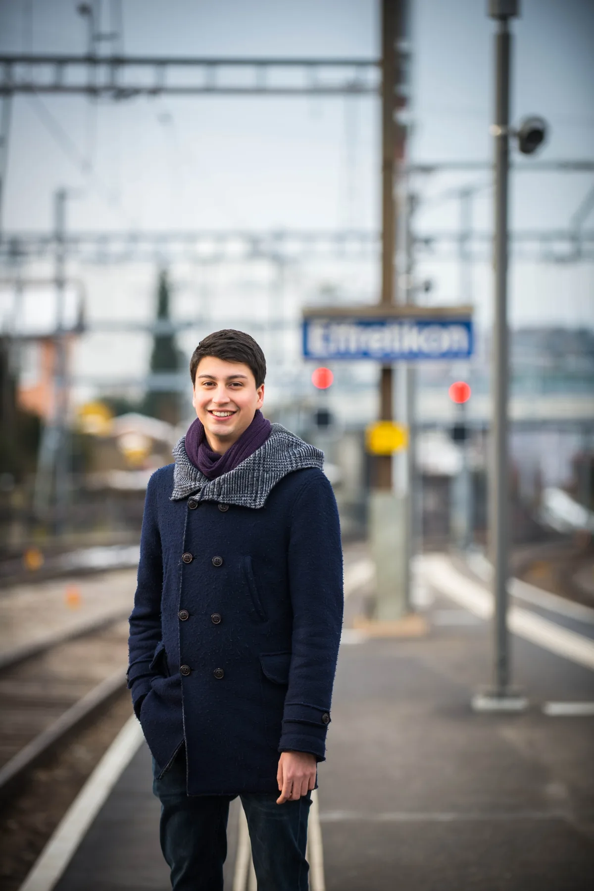 Fabian Molina lächelt am Bahnhof Effretikon für eine Fotoaufnahme in die Kamera.